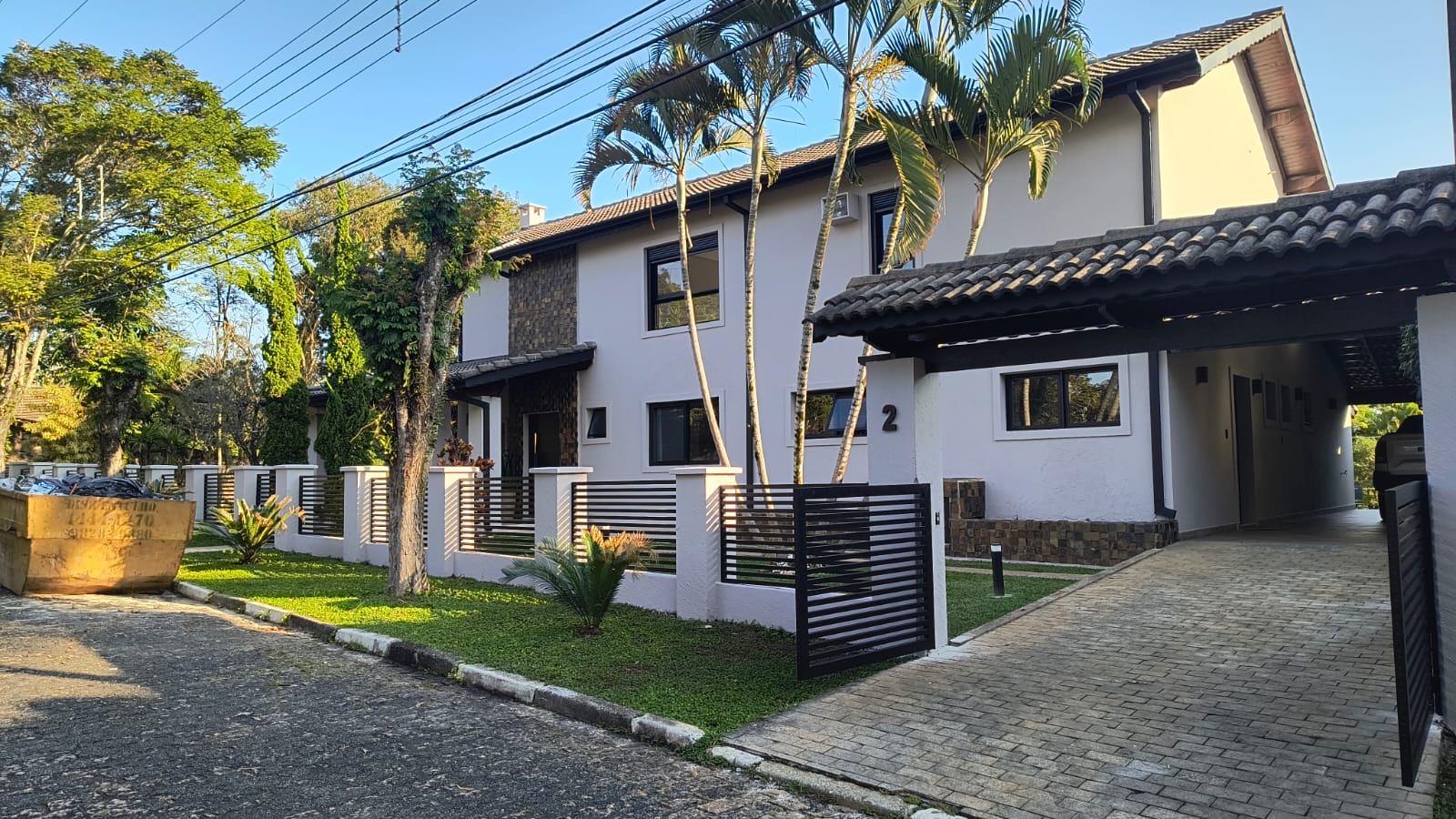 Residência branca com gradil e portão de alumínio preto